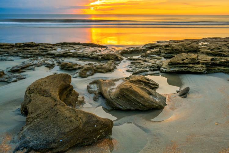 rocks on a beach at sunset