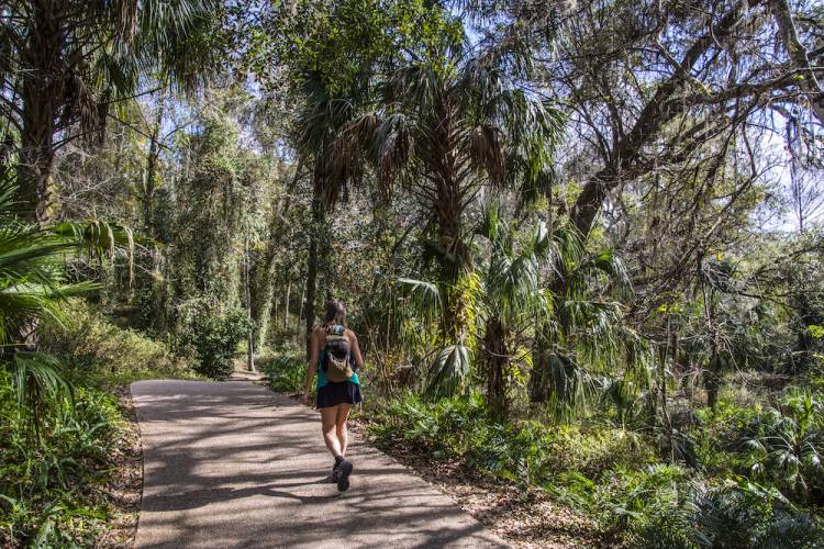 Woman hiking along a paved trail in Florida